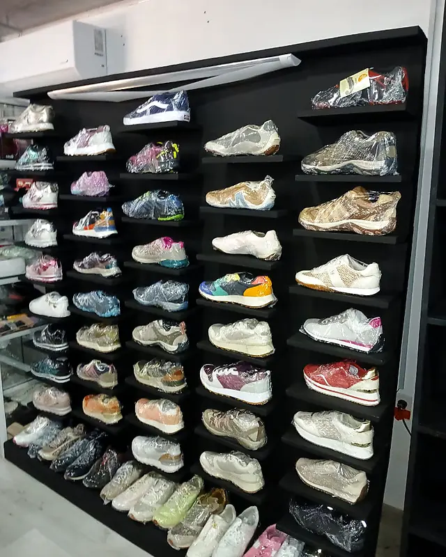 Black shoe display wall full of sneakers in a store – Lynn's Furniture