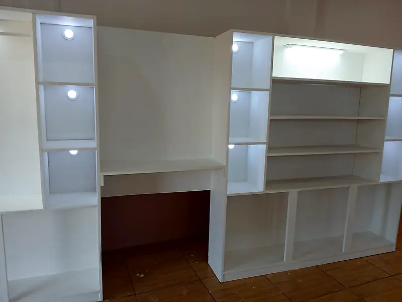 Built-in white desk and shelving unit with lights
