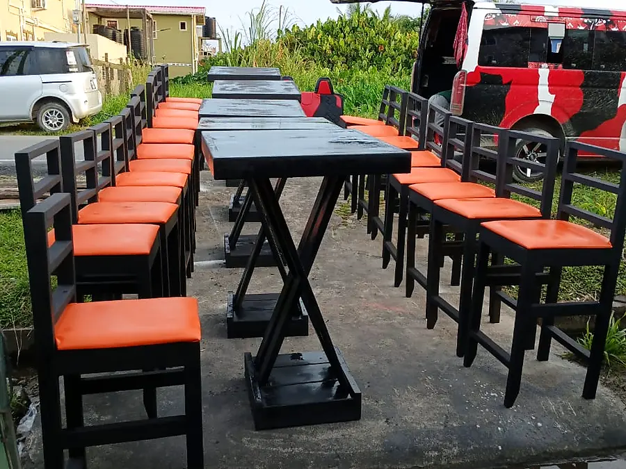 Black bar tables with matching orange-seat stools in the yard
